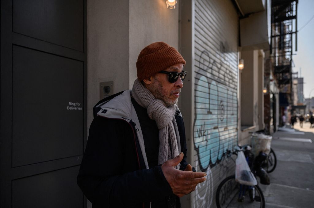 Sekou Salaam berdiri di luar Bowery Mission, sebuah organisasi nirlaba yang merawat warga New York yang tunawisma, kelaparan, dan mengalami berbagai krisis lainnya, setelah menerima makan siang gratis di New York, AS, Rabu (16/3/2022).