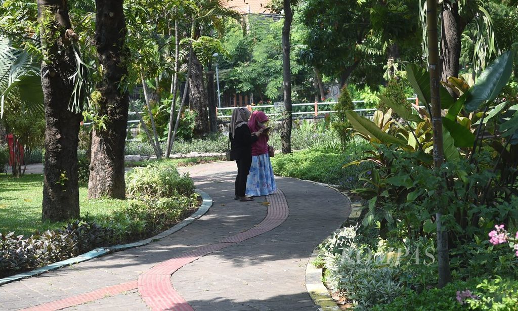 Warga menikmati teduhnya Taman Prestasi di Kota Surabaya, Sabtu (23/10/2021). Pemerintah Kota Surabaya melalui Dinas Kebersihan dan Ruang Terbuka Hijau resmi membuka taman kota dengan penerapan protokol kesehatan ketat. Dari total 39 taman di Kota Surabaya, sebanyak delapan taman kota telah dibuka.