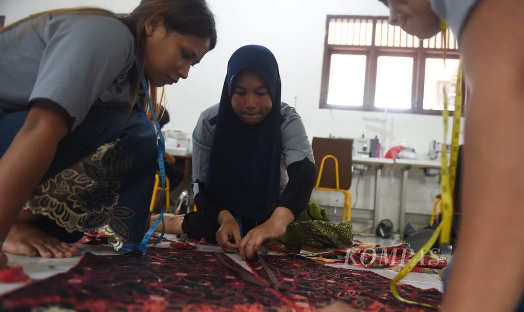 Perwakilan warga berdiskusi saat akan memasangkan retsleting pakaian saat mengikuti pelatihan menjahit di salah satu ruangan sekolah di Desa Tengin Baru, Kecamatan Sepaku, Kabupaten Penajam Paser Utara, Kalimantan Timur, Senin (25/7/2022). 