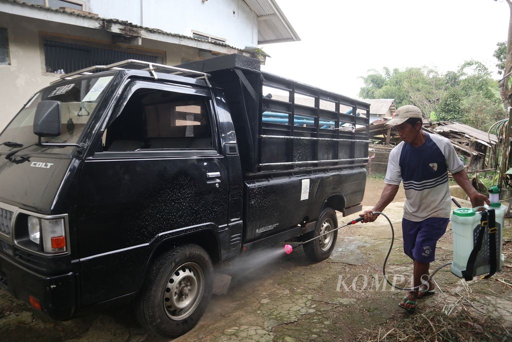 Warga menyemprotkan cairan disinfektan ke mobil pengangkut pakan sapi di Cigugur, Kabupaten Kuningan, Jawa Barat, Kamis (2/6/2022). Upaya itu untuk mengurangi potensi penularan PMK pada ternak. Hingga kini, tercatat 323 kasus PMK di Kuningan, sebanyak 264 ekor di antaranya berada di Cigugur.