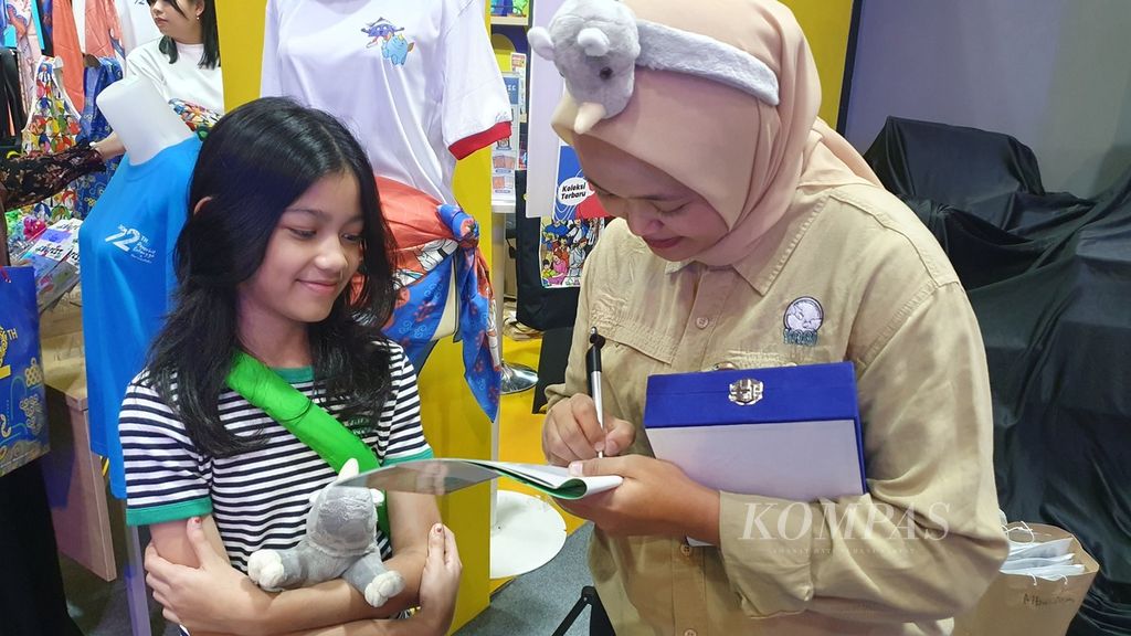 Penulis buku harian <i>Baja si Badak Jawa</i>, Nuke Arincy, dari tim edukasi Yayasan Badak Indonesia menandatangani karyanya yang diterbitkan Penerbit Erlangga dan diluncurkan di MGP Space, SCBD Park, Jakarta Selatan, Minggu (5/5/2024).