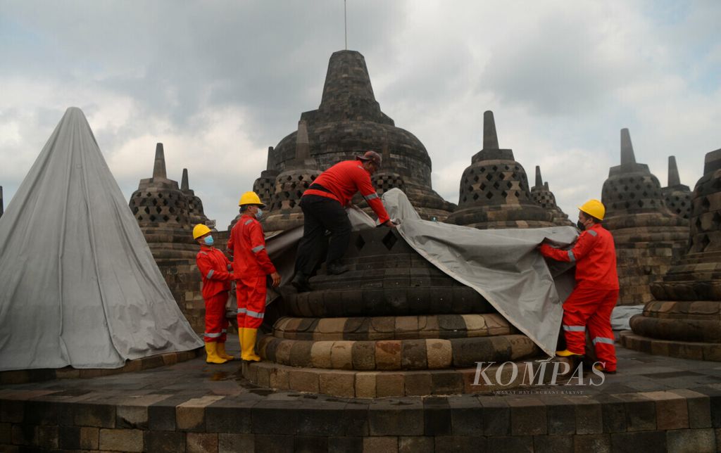 Officers remove the tarpaulin covering the stupa at Borobudur Temple, Magelang Regency, Central Java, Thursday (10/6/2021). Previously, as many as 72 stupas of this temple were closed to protect from the volcanic ash of Mount Merapi.