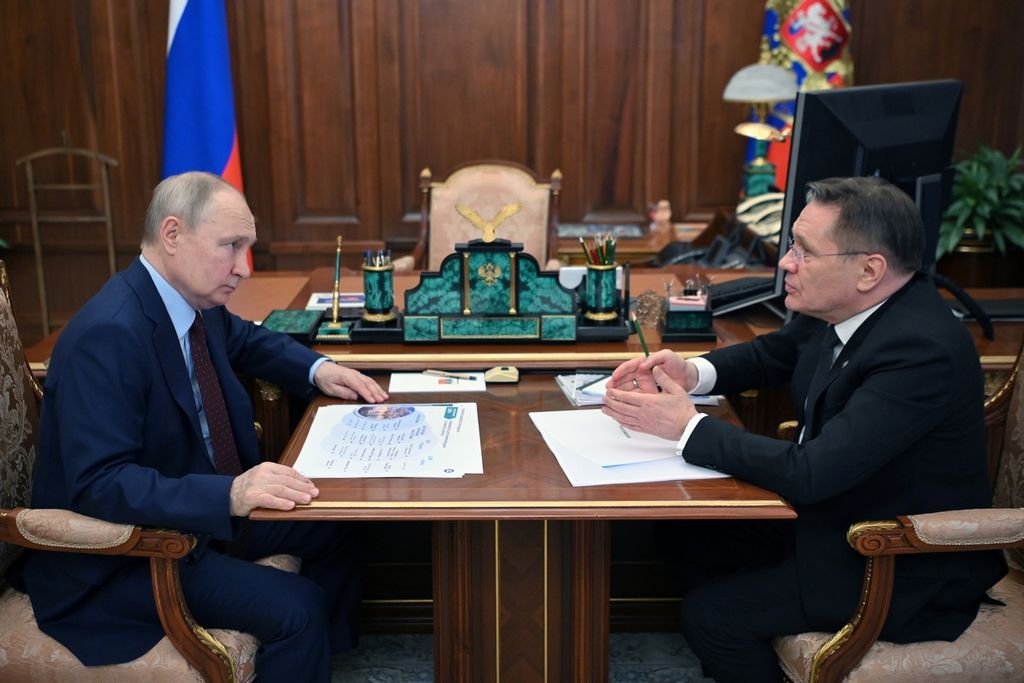 Presiden Rusia Vladimir Putin (kiri) mendengarkan Direktur Jenderal Rosatom, Alexey Likhachev, pada pertemuan di Moskwa, Senin (14/8/2023). (Alexander Kazakov, Sputnik, Kremlin Pool Photo via AP)