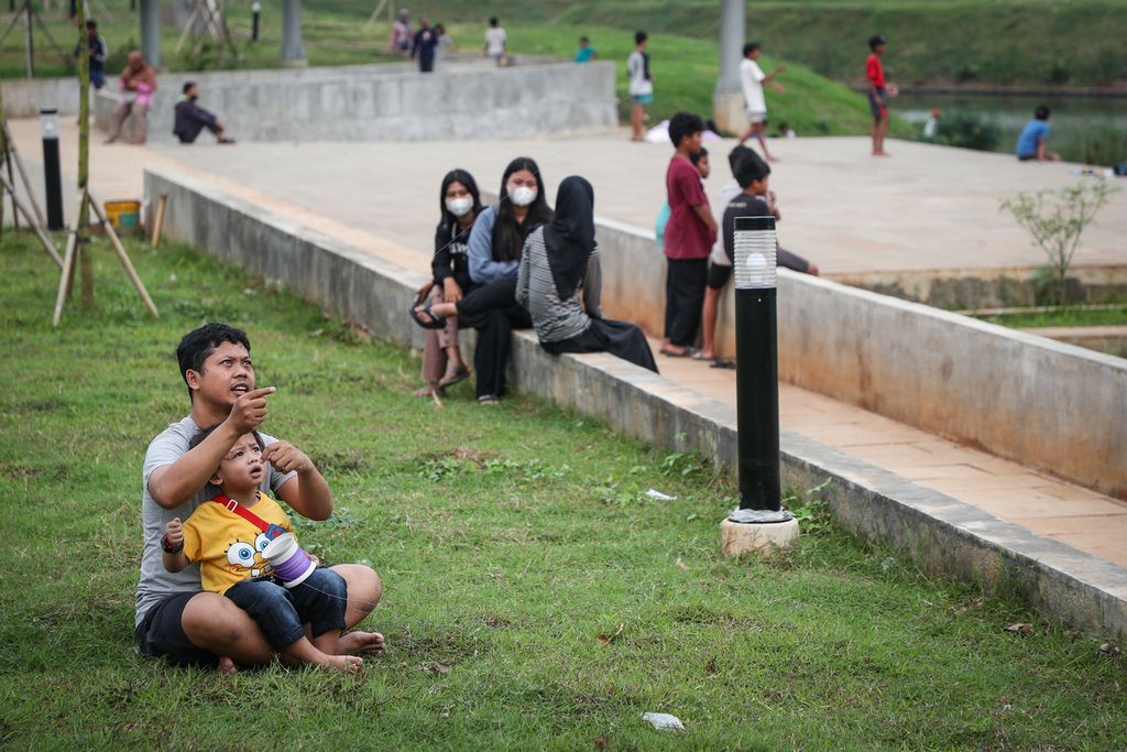 Orangtua dan anak bermain layang-layang di Ruang Limpah Sungai (RLS) Lebak Bulus, Jakarta Selatan, Kamis (18/5/2023). Selain berfungsi sebagai pengendali banjir, RLS Lebak Bulus juga berfungsi sebagai ruang terbuka hijau, ruang terbuka biru, dan ruang publik. 