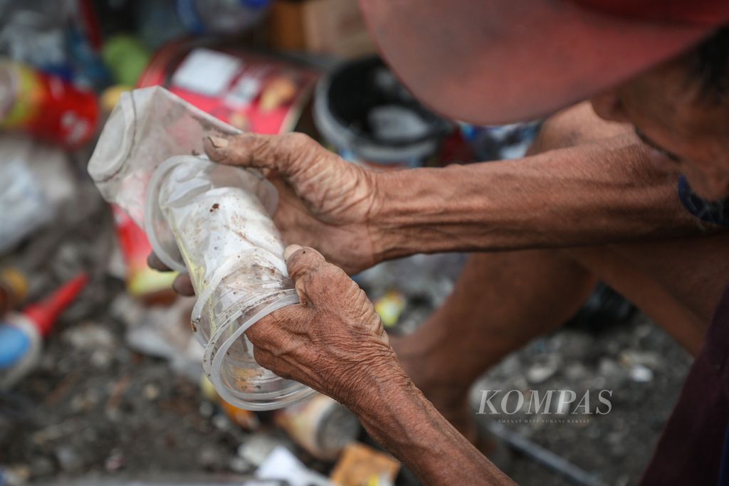 Seorang pemulung memilah sampah yang dapat dijual di Kampung Gasong, Menteng Atas, Jakarta Selatan, Senin (21/8/2023). 