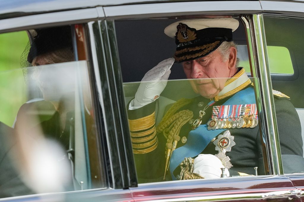 Raja Inggris Charles III memberi salam hormat setelah meninggalkan biara Westminster Abbey seusai upacara pemakaman ibunya, mendiang Ratu Elizabeth II, pada 19 September 2022. Charles akan dinobatkan sebagai Raja Inggris dalam upacara pada 6 Mei 2023. 