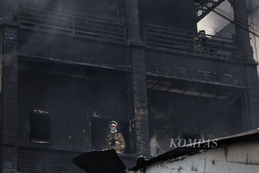 Petugas pemadam kebakaran melakukan pendinginan sisa kebakaran di Jalan Mampang Prapatan, Jakarta, Jumat (19/4/2024). Kebakaran yang melanda toko bingkai di Jalan Mampang Prapatan tersebut menewaskan tujuh orang, sedangkan lima orang lainnya mengalami luka-luka. Ketujuh korban tewas tersebut diduga terjebak di dalam toko. Kebakaran terjadi pada Kamis (18/4/2024) sekitar pukul 19.30 WIB. 