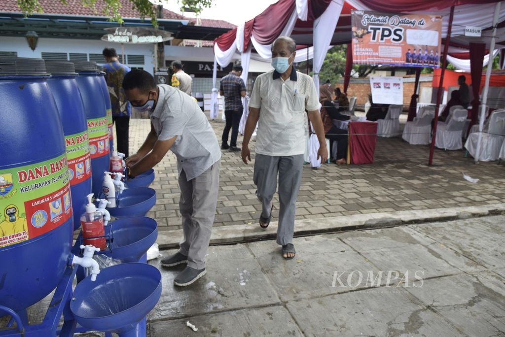 Calon pemilih terlebih dahulu mencuci tangan sebelum masuk ke dalam TPS. Protokol kesehatan diterapkan ketat demi mencegah penularan virus korona baru. Suasana di TPS 08 Telanaipura, Kota Jambi, Rabu (9/12/2020).