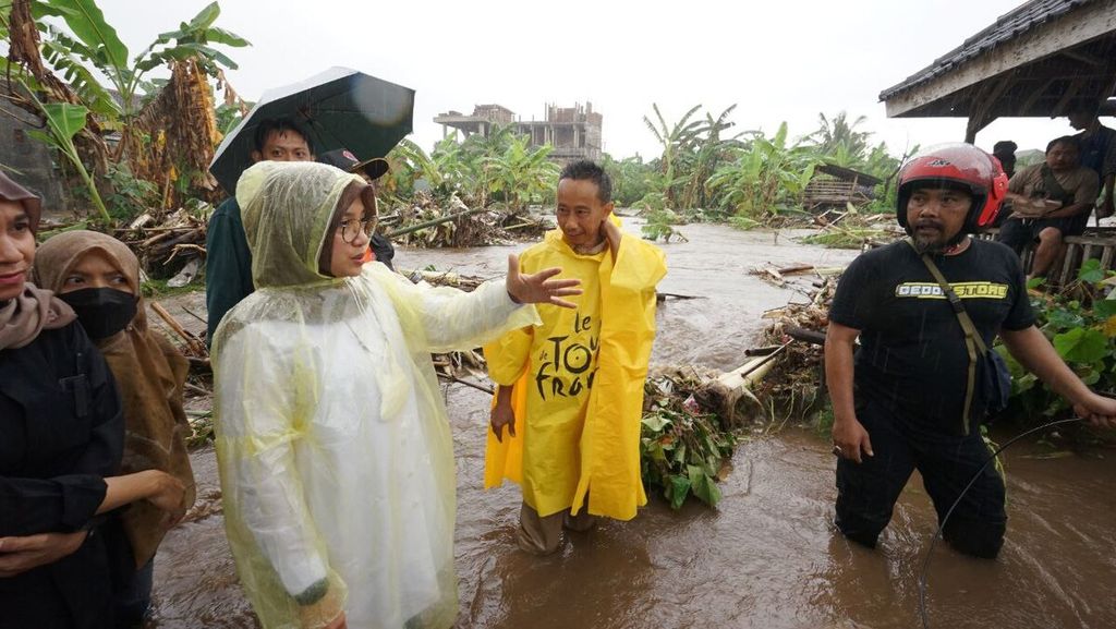 Bupati Banyuwangi Ipuk Festiandani meninjau banjir di Banyuwangi, Jawa Timur, Senin (17/1/2022). Terlihat air sungai meluap hingga ke permukiman.