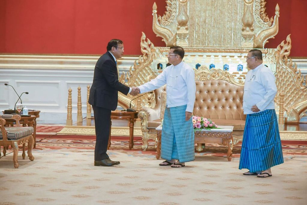 Foto yang diambil Kementerian Luar Negeri Kamboja pada 30 Juni 2022 dan dirilis pada 1 Juli 2022 ini memperlihatkan Panglima Tertinggi Angkatan Bersenjata Myanmar Jenderal Senior Min Aung Hlaing (tengah) berjabat tangan dengan Menlu Kamboja Prak Sokhonn (kiri), yang juga menjabat Utusan Khusus untuk Myanmar, di Naypyidaw, Myanmar. 