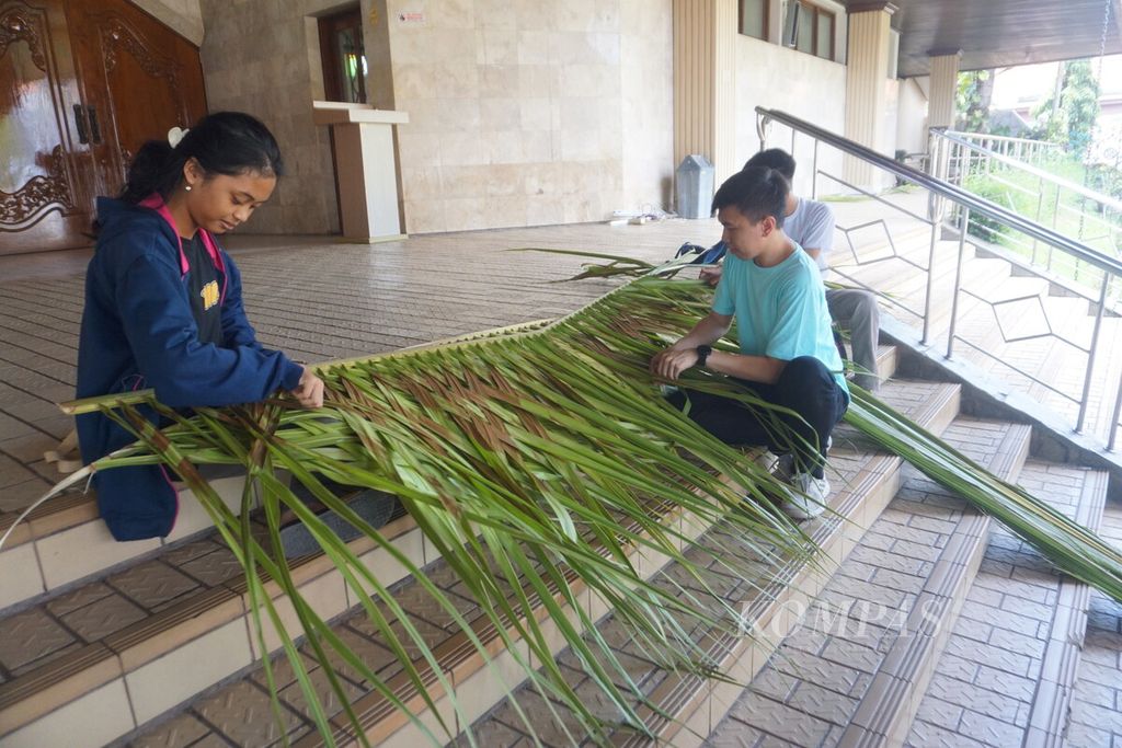 Umat menyiapkan anyaman janur untuk membuat pohon natal di halaman Gereja Katedral Kristus Raja Purwokerto, Kabupaten Banyumas, Jawa Tengah, Kamis (21/12/2023).