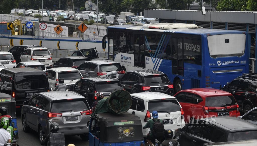 Bus Transjakarta melewati Jalan Hayam Wuruk, Jakarta Pusat, saat berlangsung pekerjaan konstruksi paket kontrak 202 (CP202) proyek MRT Jakarta fase 2A, Selasa (17/1/2022).
