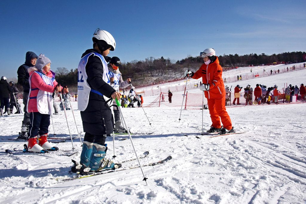 Seorang instruktur ski memberikan instruksi di sebuah resor ski di Qingdao, Provinsi Shandong, China timur, pada 25 Januari 2023. Selama liburan Festival Musim Semi, resor-resor ski di Qingdao melakukan persiapan penuh untuk meningkatkan pengalaman konsumsi dan memenuhi permintaan wisatawan yang jumlahnya semakin banyak. 