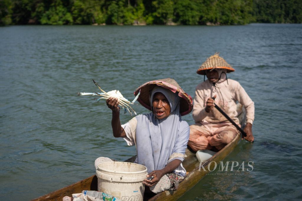 Rahi Ginuni menunjukkan rajungan yang berhasil ditangkap dengan bubu, Selasa (27/6/2023). Rahi dan suaminya, Sidik Heritrenggi, bekerja sebagai pencari rajungan dan kepiting di Kampung Mandoni, Distrik Kokas, Kabupaten Fakfak, Papua Barat.