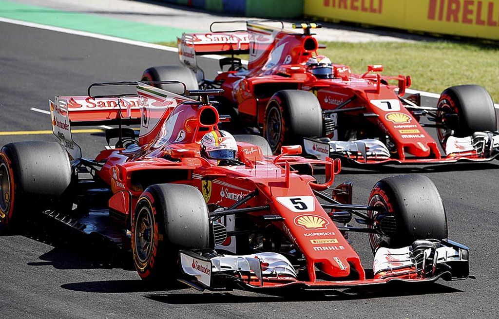 Pebalap Ferrari, Sebastian Vettel  (5), dan rekan setimnya, Kimi Raikkonen, menjalani sesi kualifikasi GP Hongaria di Sirkuit Hungaroring, Budapest, Sabtu (29/7). Vettel meraih posisi start terdepan disusul Raikkonen, dan pebalap Mercedes, Valtteri Bottas.