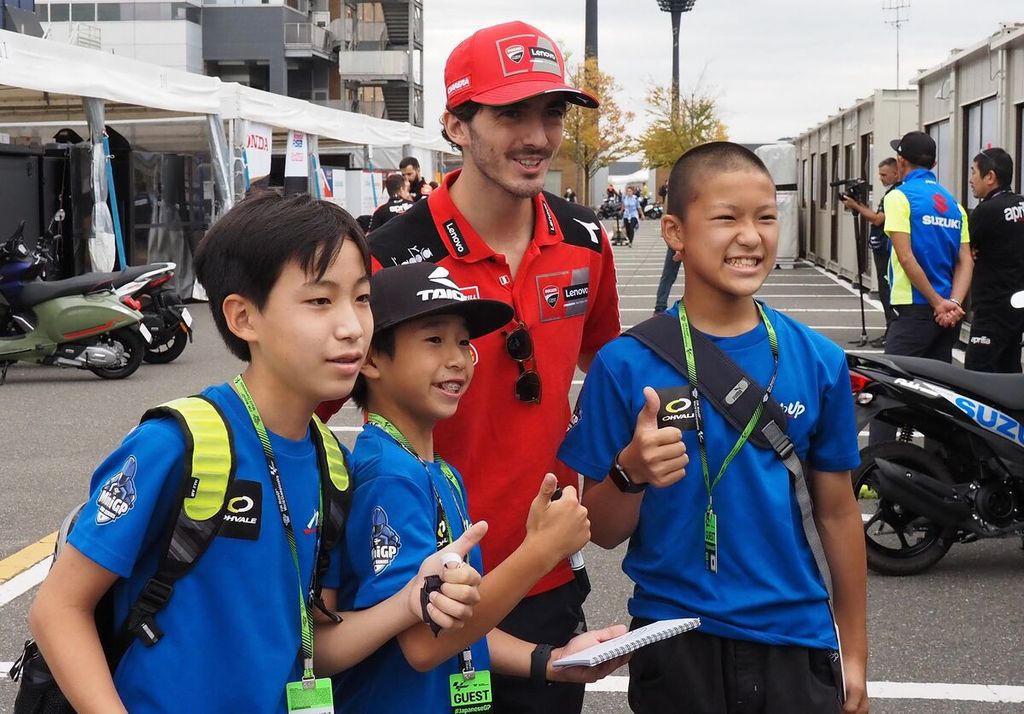 Pebalap Ducati Lenovo Francesco Bagnaia berpose bersama anak-anak di paddock di Sirkuit Twin Ring Motegi, Prefektur Tochigi, Jepang, Kamis (22/9/2022). Balapan MotoGP seri Jepang di Sirkuit Twin Ring Motegi akan berlangsung Jumat-Minggu (23-25/9/2022). 