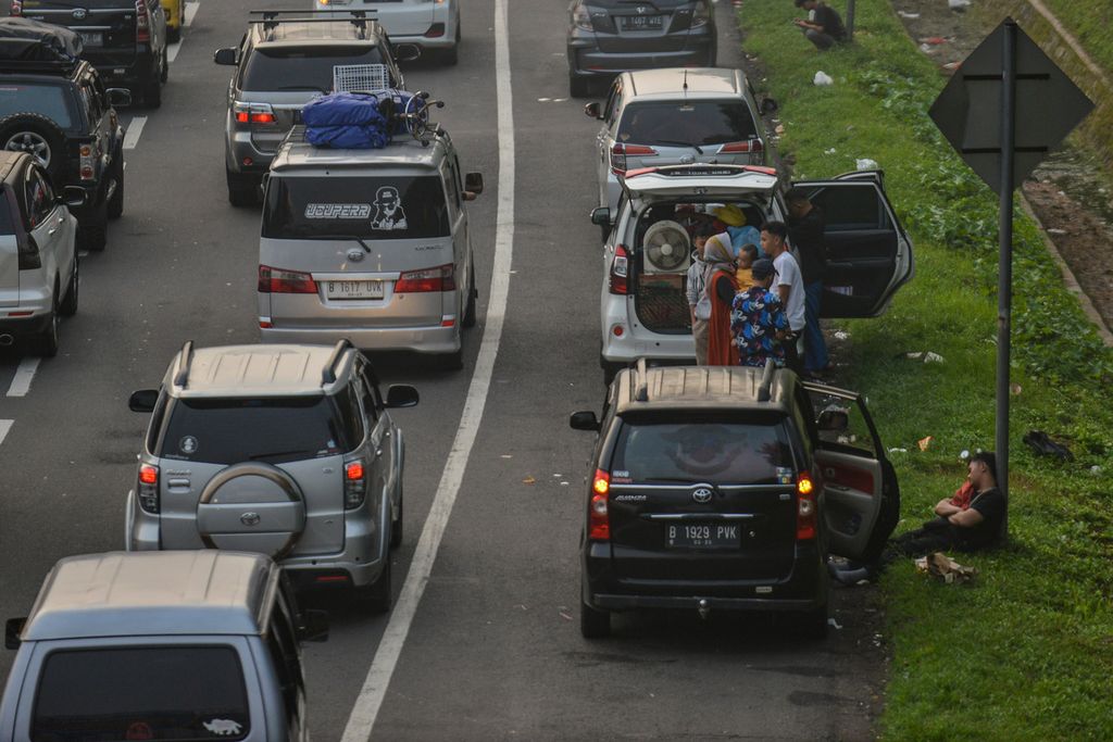 sejumlah pemudik beristirahat di bahu jalan Kilometer (Km) 72 Tol Cipali, Karawang, Jawa Barat, Kamis (20/4/2023). Para pemudik yang kelelahan terlihat beristirahat di bahu jalan. 