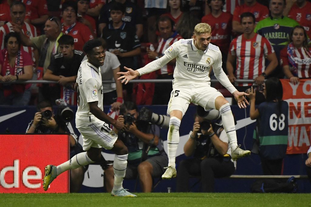Pemain Real Madrid, Federico Valverde (kanan), merayakan golnya ke gawang Atletico Madrid pada laga Liga Spanyol di Stadion Wanda Metropolitano, Madrid, Minggu (18/9/2022). Real Madrid menang 2-1 pada laga itu. 