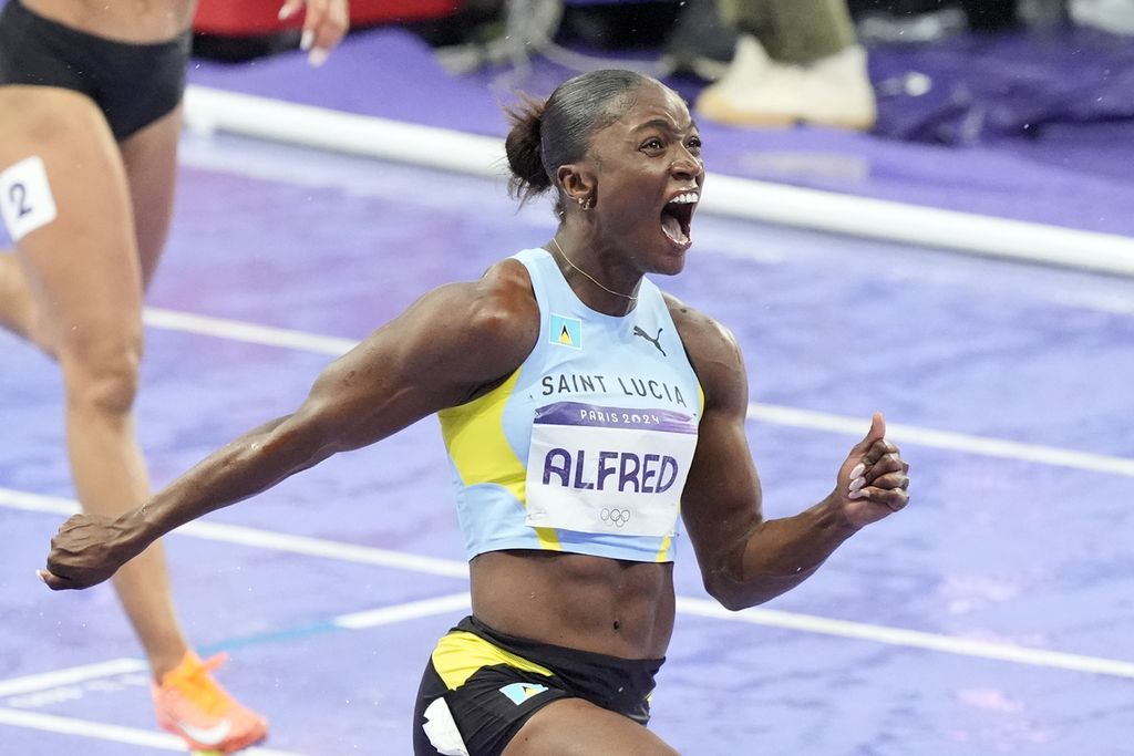 Julien Alfred, sprinter Saint Lucia, merayakan kemenangan pada final nomor lari 100 meter putri Olimpiade Paris 2024, Minggu (4/8/2024) WIB, di Stade de France, Perancis. Ia meraih medali emas.