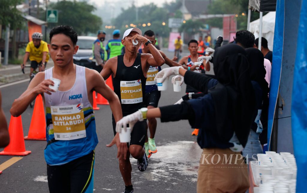 Petugas yang menyiapkan kebutuhan air minum bagi para atlet Elite Race kategori putra dan putri saat Borobudur Marathon 2022 Powered by Bank Jateng di kawasan Candi Borobudur, Jawa Tengah, Sabtu (12/11/2022). 