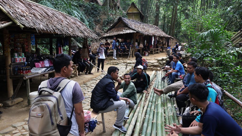 Wisatawan beristirahat di bantaran Sungai CIujung di Kampung Gajeboh, Desa Kanekes, Kecamatan Leuwidamar, Kabupaten Lebak, Banten, Minggu (18/9/2023). 
