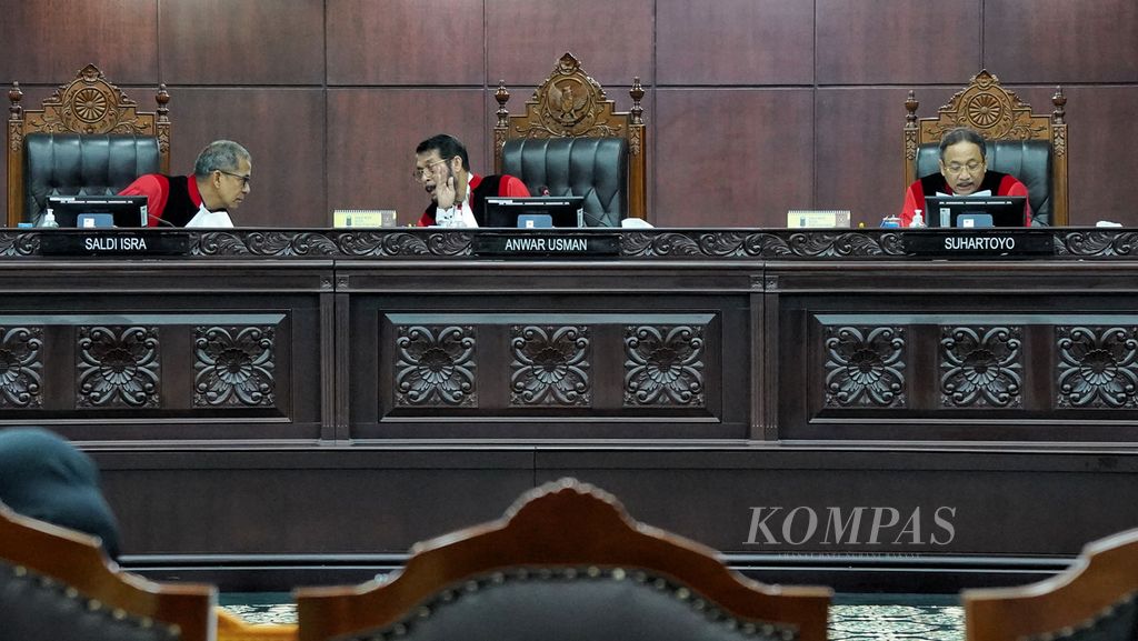 Ketua Mahkamah Konstitusi (MK) Anwar Usman (tengah) berdiskusi dengan hakim MK Saldi Isra (kiri) saat hakim MK Suhartoyo (kanan) saat sidang pembacaan putusan uji materi batas usia minimal capres dan cawapres di Gedung MK, Jakarta, Senin (16/10/2023). 