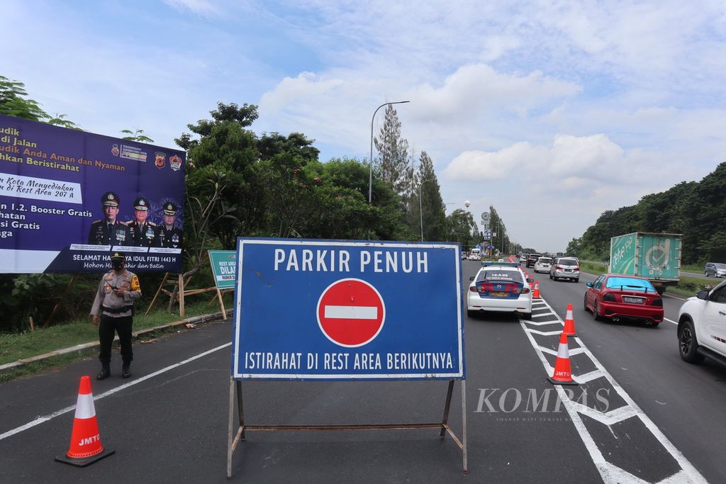 Polisi mengarahkan pengendara agar tidak masuk <i>rest area</i> 207A di Jalan Tol Palimanan-Kanci, Cirebon, Jawa Barat, Kamis (28/4/2022). Pengelola jalan tol dan kepolisian kembali menerapkan sistem buka-tutup area istirahat untuk mengurai kepadatan.