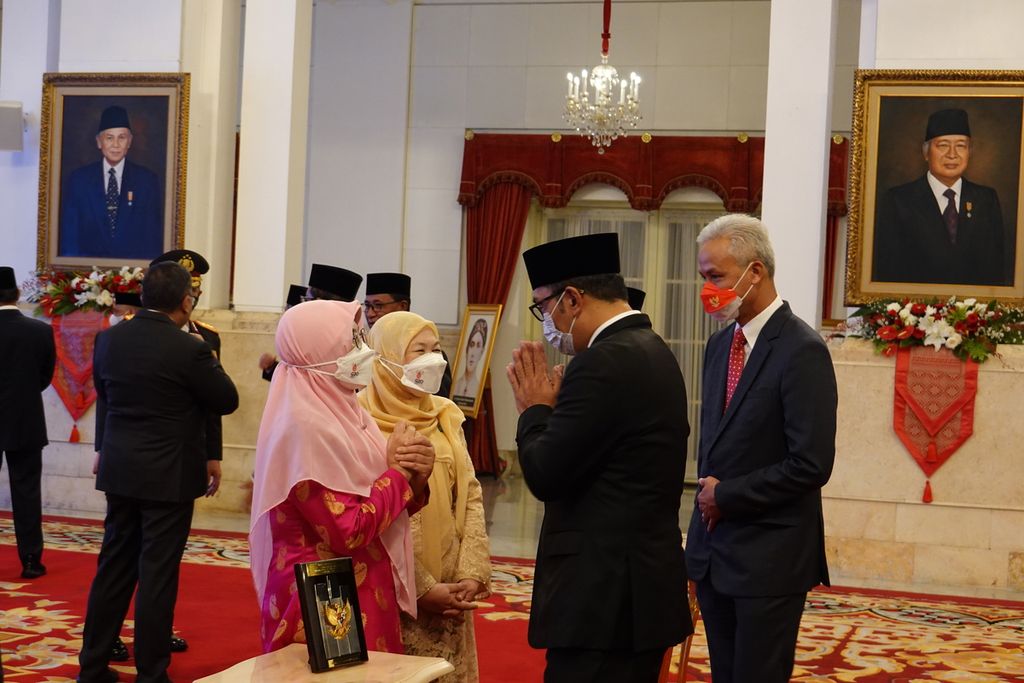Gubernur Jawa Tengah Ganjar Pranowo dan Gubernur Jawa Barat Ridwan Kamil memberikan selamat kepada ahli waris dalam penganugerahan gelar pahlawan nasional, di Istana Negara, Jakarta (7/11/2022).
