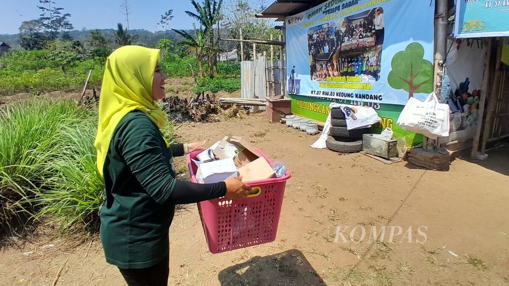 Relawan membawa sampah kertas menuju Tempat Pemilah Sampah Barokah atau Tempe Sabar di wilayah RT 007 RW 003 Kelurahan/Kecamatan Kedungkandang, Kota Malang, Jawa Timur, Minggu (13/8/2023).