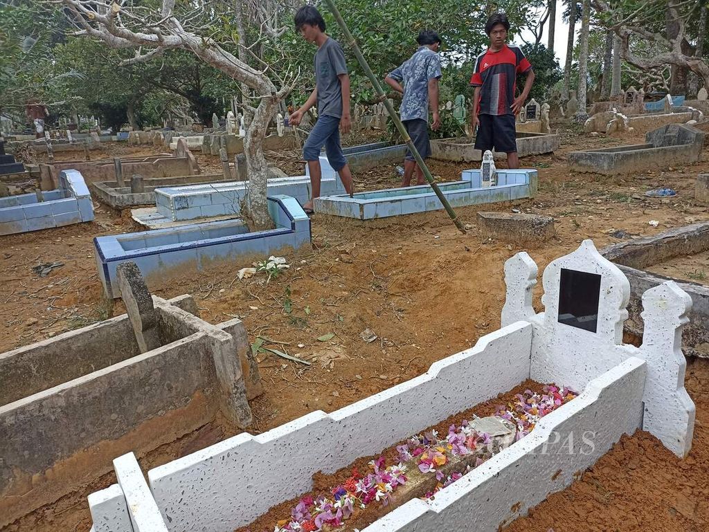 Warga melihat makam Abdul Sidik (berwarna putih) di Kelurahan Sawit Seberang, Kecamatan Sawit Seberang, Kabupaten Langkat, Sumatera Utara, Sabtu (12/2/2022). 
