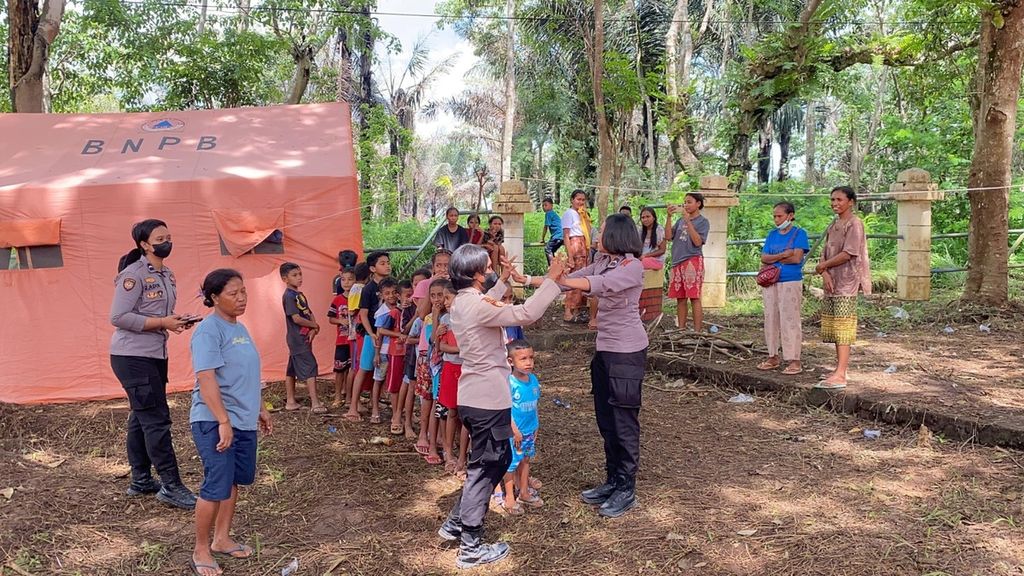 Sejumlah polisi wanita yang membantu Polres Flores Timur sedang memberikan<i> trauma healing</i> kepada anak-anak korban erupsi Gunung Lewotobi Laki-laki berupa kegiatan bermain dan kreasi bersama.