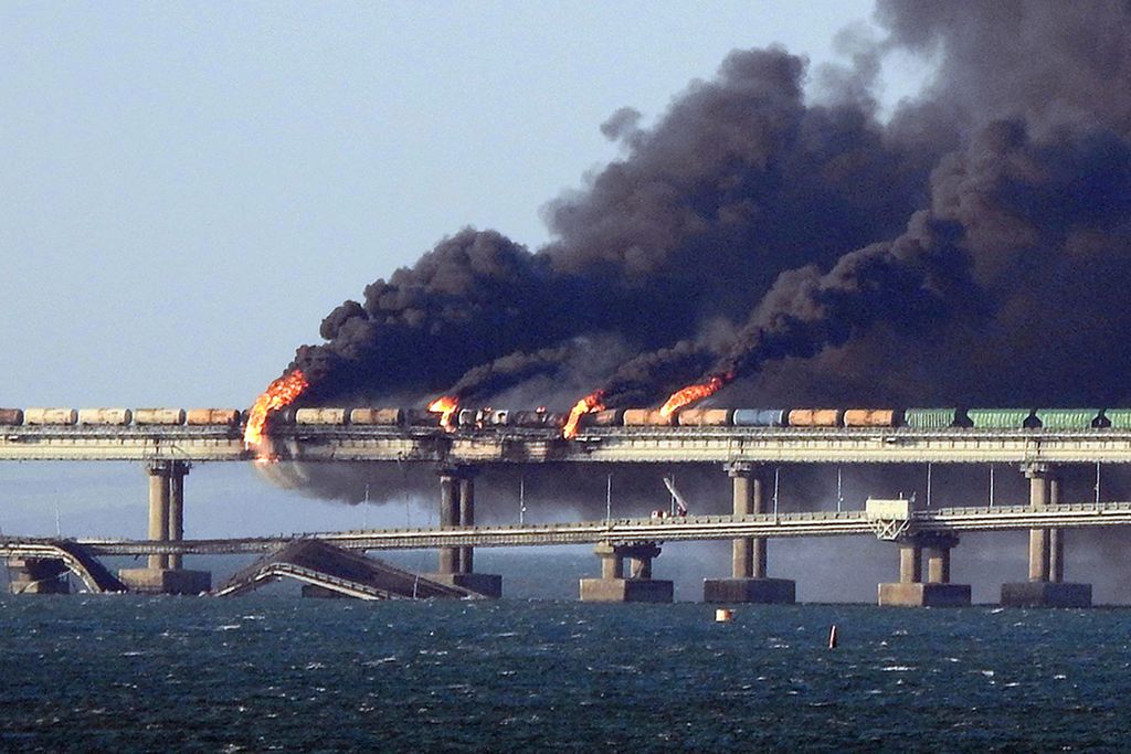 Kobaran api dan asap hitam membubung dari Jembatan Kerch, penghubung wilayah Rusia dan Semenanjung Crimea, Sabtu (8/10/2022).  Jembatan Kerch adalah akses utama Rusia dalam distribusi logistik untuk militer Rusia yang beroperasi di Ukraina Selatan.