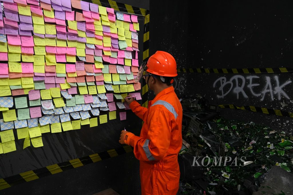 Pengunjung menulis <i>uneg-uneg</i> setelah melampiaskan amarahnya dengan memecahkan botol di Breakroom, Kota Bandung, Jawa Barat, Rabu (31/7/2024). Breakroom Bandung yang berdiri tiga bulan yang lalu adalah sebuah tempat atau ruangan untuk melampiaskan amarah dengan memecahkan botol, televisi, <i>printer </i>hingga <i>dispenser</i>. 