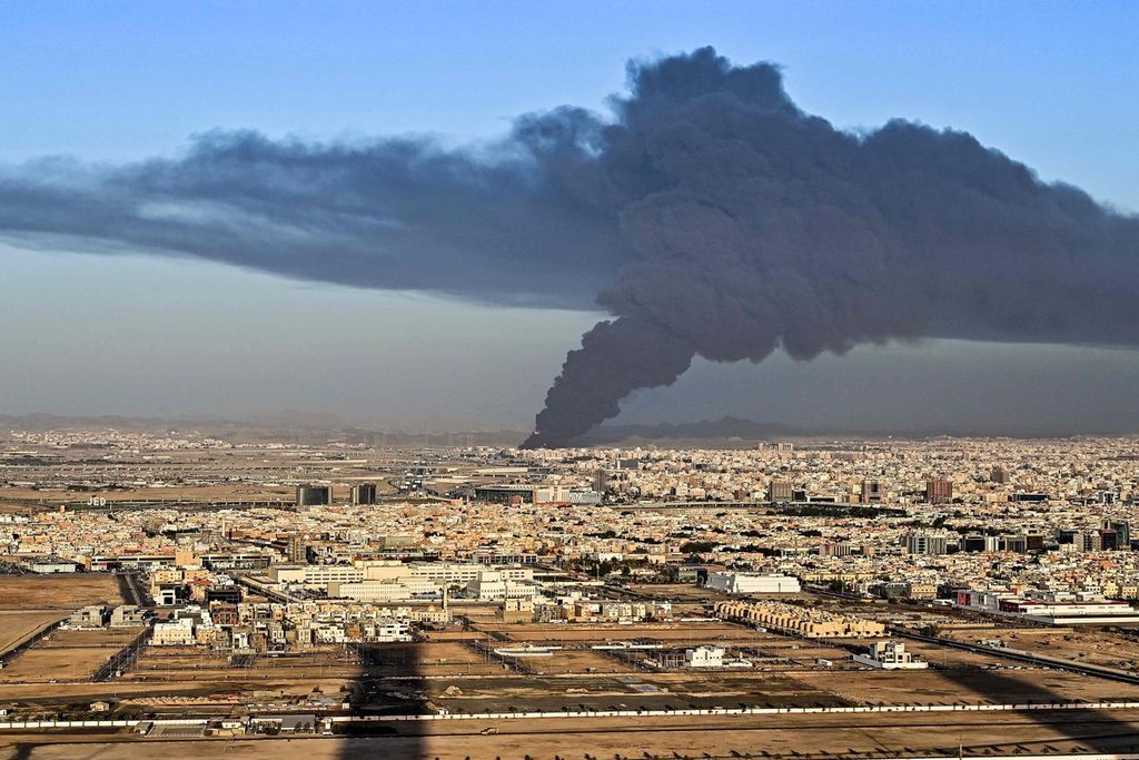 Asap dan kobaran api membubung ke angkasa dari fasilitas minyak Aramco Saudi di Jeddah, kota di tepi Laut Merah, Arab Saudi, Jumat (25/3/2022), menyusul serangan kelompok Houthi dari Yaman. 