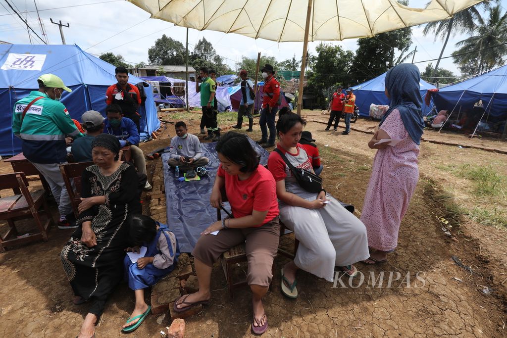 Warga korban gempa menanti giliran untuk pemeriksaan kesehatan di Kecamatan Gintung, Kabupaten Cianjur, Jawa Barat, Kamis (1/12/2022).