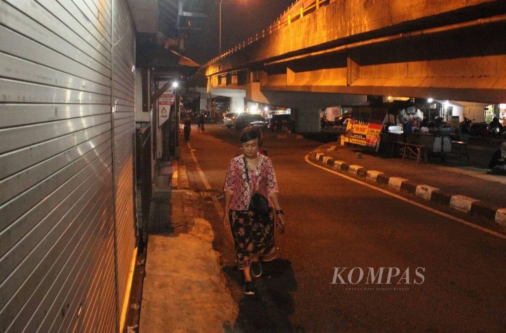 Transpuan pengamen, Rully Mallay (62), pulang dari mengamen di warung-warung lesehan di bawah Jembatan Layang Janti, DI Yogyakarta, Rabu (20/7/2022) malam. Ia mengamen di Yogyakarta sejak 2003.