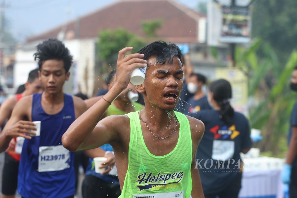 Pelari mengguyurkan air ke kepala dalam ajang Borobudur Marathon Powered by Bank Jateng di kompleks Candi Borobudur, Magelang, Jawa Tengah, Minggu (19/11/2023). Sekitar 10.000 pelari mengikuti ajang lomba lari yang terbagi dalam tiga kategori, yakni maraton (42 kilometer), separuh maraton (21 kilometer), dan 10 kilometer, ini. 