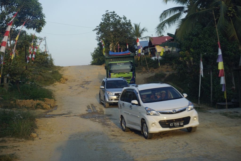Mobil melintas di jalan rusak di jalan raya Samboja-Sepaku Desa Suko Mulyo, Kecamatan Sepaku, Penajam Paser Utara, Kalimantan Timur, Rabu (28/8/2019). Wilayah ini berada di perbatasan Kabupaten Kutai Kartanegara yang disebut menjadi lokasi ibu kota baru.