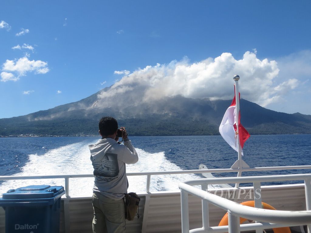 Seorang warga Kabupaten Sitaro memotret erupsi Gunung Karangetang di Pulau Siau, Sulawesi Utara, Mei 2015, dari kapal penumpang yang transit di Pelabuhan Siau.