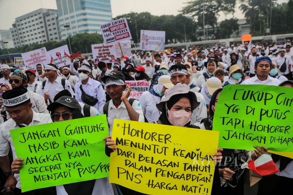 Temporary workers carried posters containing their demands during a rally in front of the House of Representatives building in Jakarta on Monday (7/8/2023). The participants, who were temporary workers, demanded a revision of Government Regulation Number 49 of 2018 concerning the management of government employees with employment agreements (PPPK) by including direct appointment as PPPK without educational level limitations.
