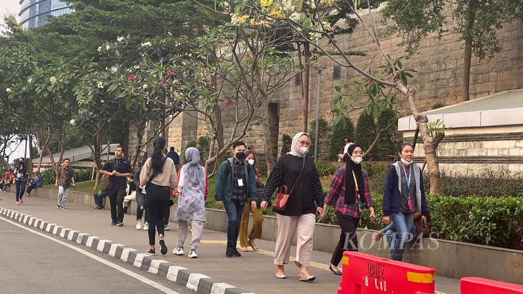 Beberapa warga melintasi trotoar di kawasan Stasiun MRT Dukuh Atas, Jumat (11/8/2023).