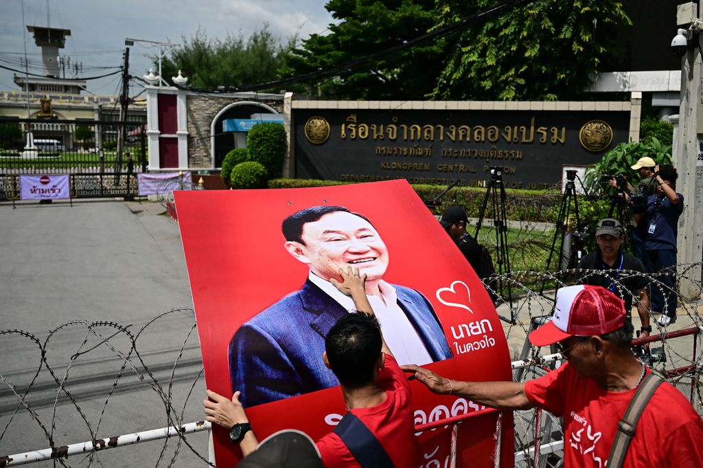 Pendukung Thaksin Shinawatra meletakkan plakat besar bergambar foto Thaksin ketika mereka menunggu  di luar pagar Penjara Klong Prem di Bangkok pada Selasa (22/8/2023) lalu.