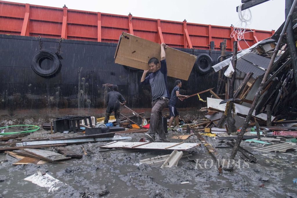 Sejumlah warga berupaya menyelamatkan barang berharga dari reruntuhan rumah mereka di Kampung Tengah, Kelurahan Tanjung Uma, Kecamatan Lubuk Baja, Kota Batam, Kepulauan Riau, Jumat (1/1/2021). 