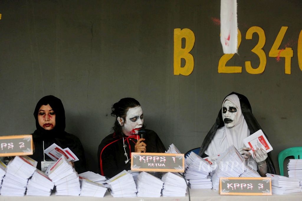 Petugas KPPS tempat pemungutan suara 073, Lebak Bulus, Jakarta Selatan, mengenakan kostum hantu saat melayani warga yang hendak memberikan suara di bilik suara, April 2019. Suasana horor tersebut diciptakan untuk menarik minat warga datang ke TPS. 