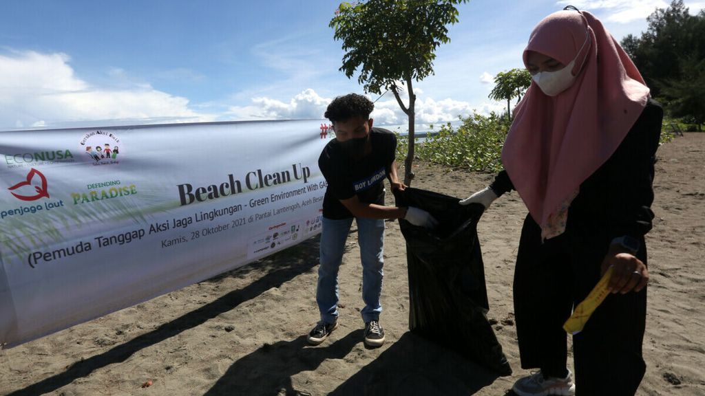 Pemuda dan pemudi yang tergabung dalam gerakan aksi baik yang difasilitasi Yayasan Econusa dan penjaga laut membersihkan sampah di pantai Desa Lam Teungoh, Kecamatan Peukan Bada, Aceh Besar, Aceh, Kamis (28/10/2021).