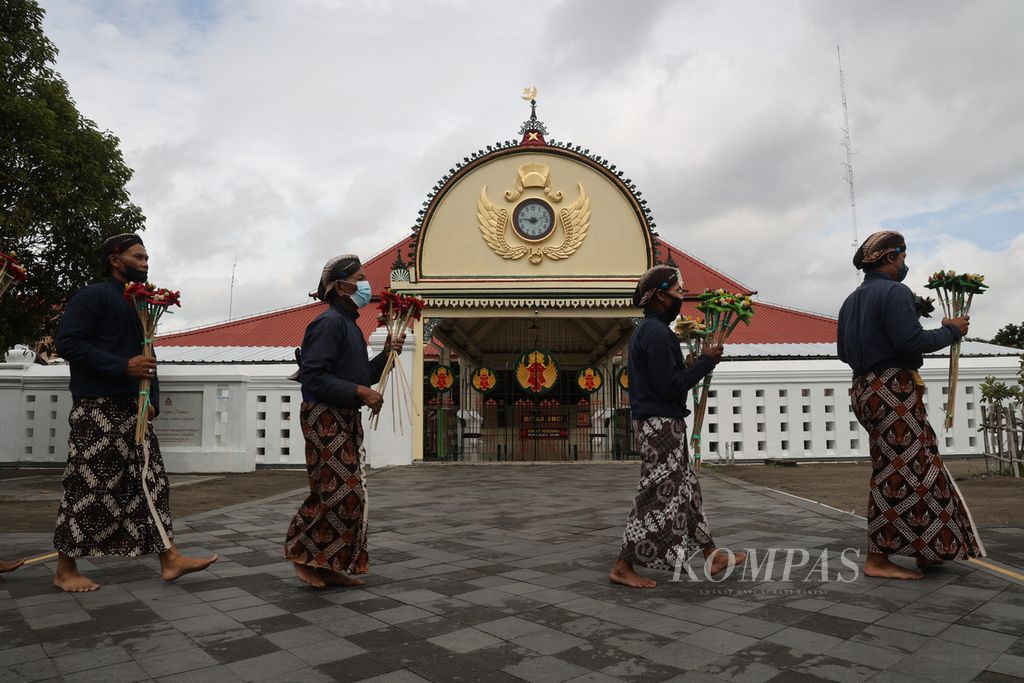Abdi dalem berjalan kaki membawa <i>uba rampe </i>atau kelengkapan gunungan dari Keraton Yogyakarta menuju kompleks Masjid Gedhe Kauman, Yogyakarta, Sabtu (8/10/2022), dalam rangkaian perayaan Maulid Nabi.