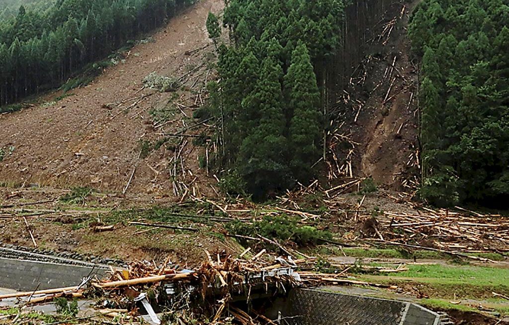 Bukit yang longsor  akibat banjir yang melanda wilayah Asakura, Jepang, Minggu (9/7). Jumlah korban tewas akibat banjir dan longsor mencapai 18 orang, sementara 27 orang lagi belum diketahui nasibnya. 