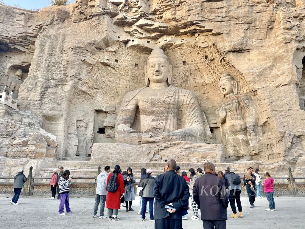Patung Budha raksasa ini berada di kompleks Situs Warisan Dunia UNESCO di Kota Datong, Provinsi Shanxi, China. Suasana di dalam situs ramai dikunjungi warga yang berlibur akhir pekan, Sabtu (21/10/2023).