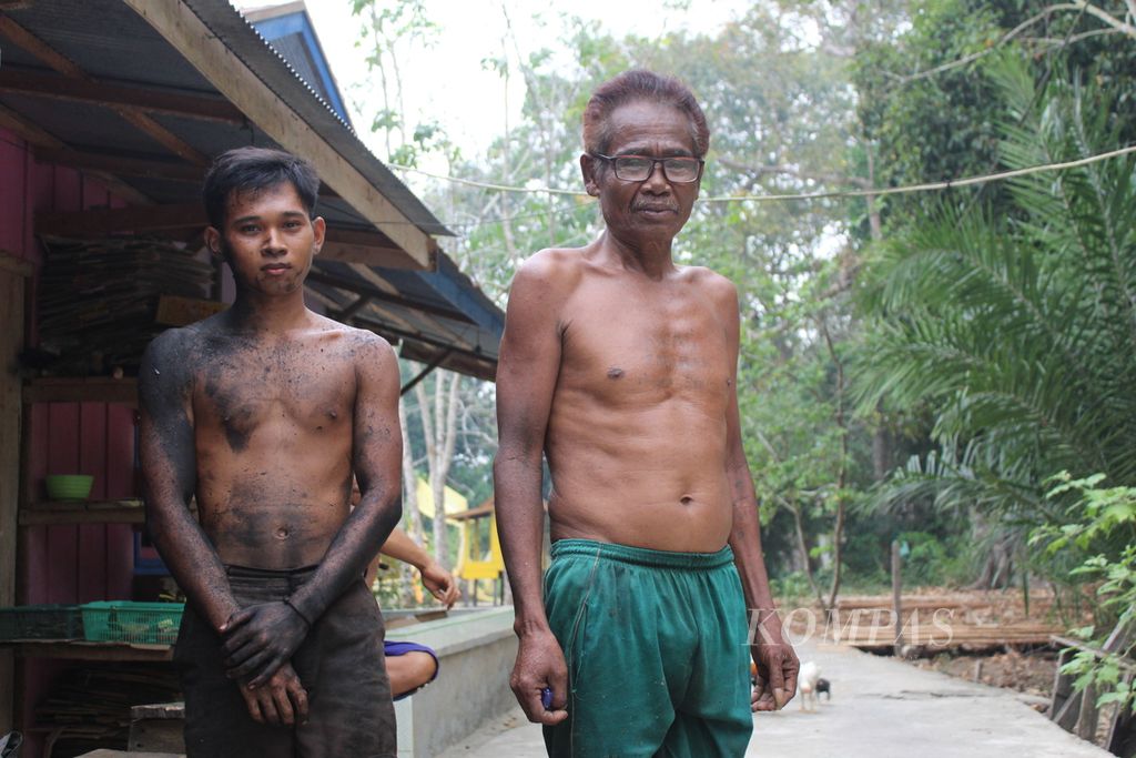 Asraf (67) dan cucunya, Arifin (19), baru saja pulang dari kebunnya yang terbakar di Desa Simpur, Kabupaten Pulang PIsau, Kalimantan Tengah, Selasa (3/10/2023). 