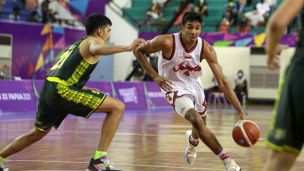 Male basketball player from DKI Jakarta team, Ali Bagir Wayarabi Alhadar (right), tries to pass male basketball player from East Java team, Ikram Fadhil (left), during the semifinal round of the 2021 Papua National Sports Week basketball competition at the Mimika Sport Complex Basketball Hall, Timika City, Mimika Regency, Papua, on Thursday (7/10/2021).